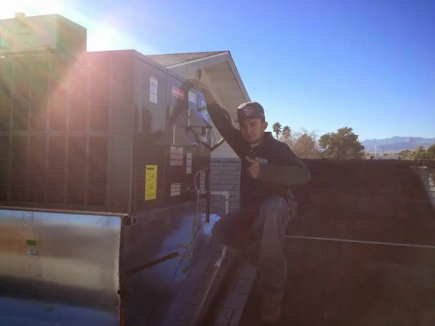 HVAC technician performing HVAC Inspection on a rooftop unit in Hallsville